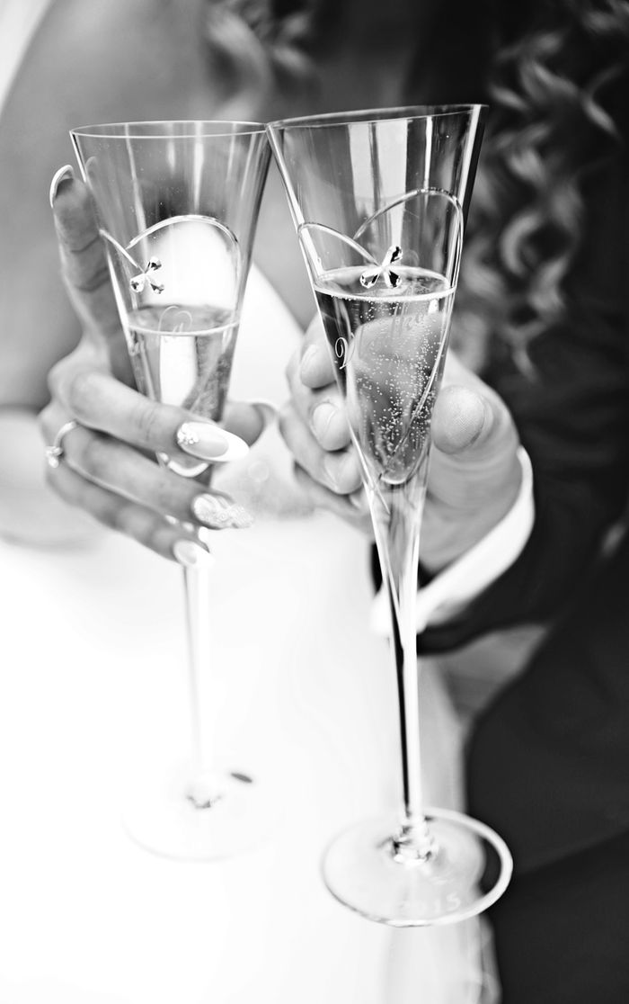 Elegant black and white image of hands toasting with champagne glasses, perfect for wedding themes.