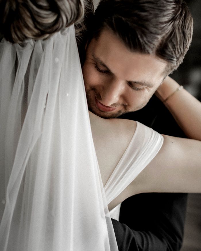 Close-up portrait of a bride and groom embracing during their wedding.