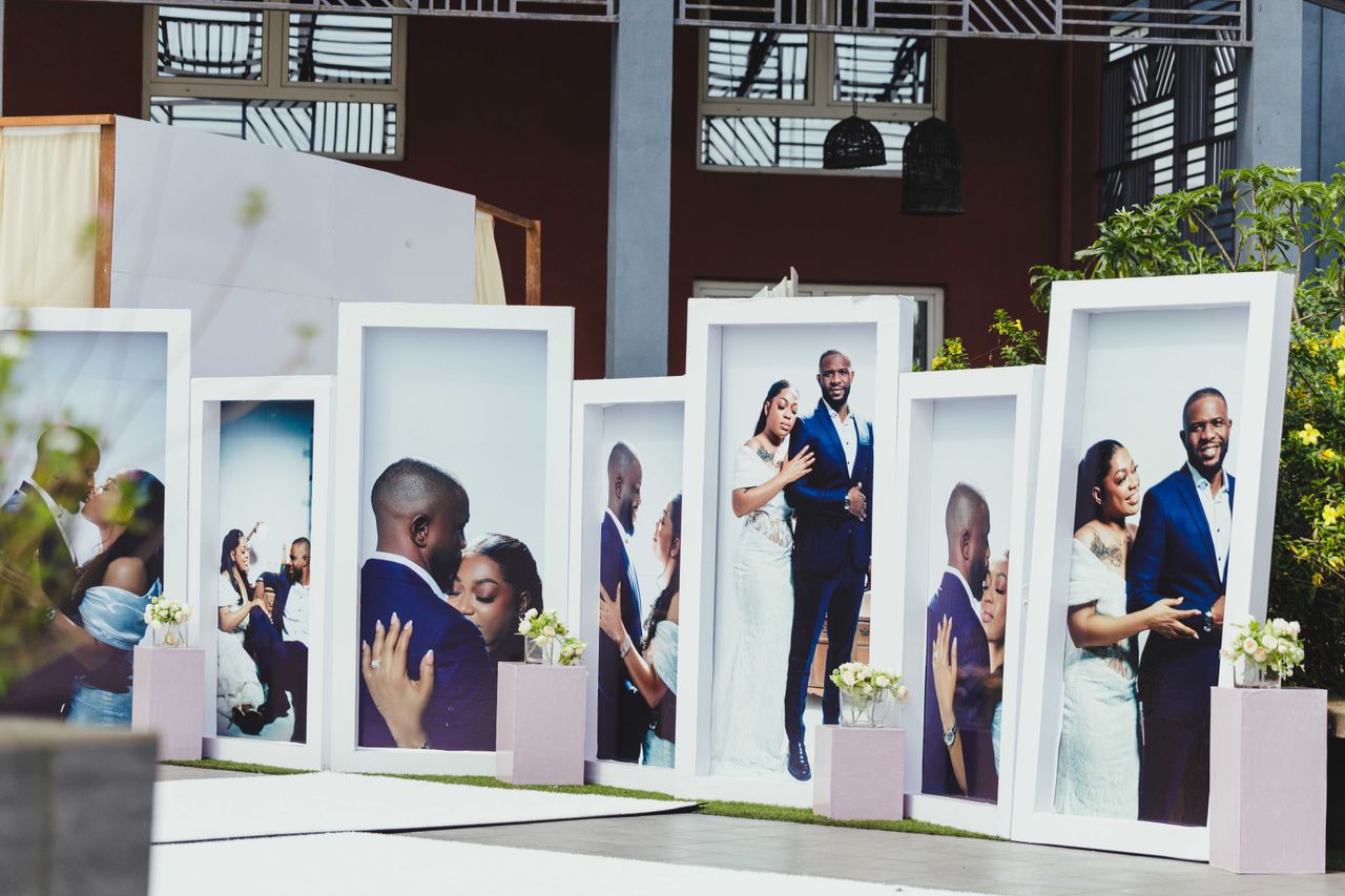 Large portrait displays at an African outdoor wedding showcasing a couple's special moments.